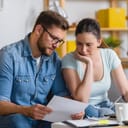A couple worriedly looking at some documents