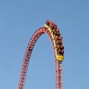People riding a tall rollercoaster
