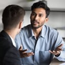 close-up of a young male entrepreneur discussing project details with a business partner at an office workspace