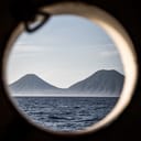 View of the seaside and mountains from a cabin window