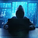 Artistic depiction of an anonymous hacker at laptop mixed together with binary information