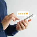 A closeup of a person giving a five start rating using their phone