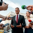 Politician and assistant being interviewed by journalists