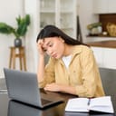 Tired-looking woman using a laptop computer