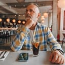 Close-up of a mature man patiently waiting his order in a café setting.