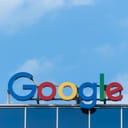 Google sign on the top of the building with blue sky in the background