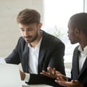 Two businessmen arguing over errors in a business document after feedback.