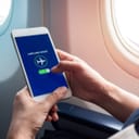 Person switching their smartphone to airplane mode inside an airplane