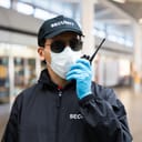 Security guard in face mask standing in an airport terminal