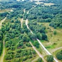 aerial image of a road going through a green forest