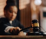 Female judge striking the gavel against the sound block in a courtroom