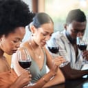 A group of well dressed people smelling wine from wine glasses