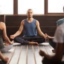 An instructor and his class meditating