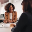 Two women at a business meeting with the one smiling in focus