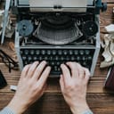 Person typing on vintage mechanical typewriter