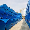blue oil barrels or chemical drums neatly stacked in a temporary storage