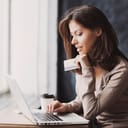 Woman holding a credit card browsing on her laptop