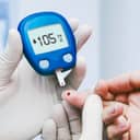 Health worker taking a blood sample from a person's finger with a digital glucose monitor