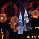 Nighttime fireworks display above Petronas Towers in Kuala Lumpur