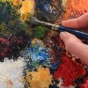 Close-up of a paintbrush on an abstract oil painting