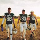 Three rugby players walking of the field triumphantly