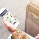 Woman using rideshare app. Ride share application in mobile phone. Commuter ordering taxi or carpool service with smartphone. Travel and modern transportation technology concept.