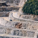 View of a quarry from a distance with a single truck driving on its slopes