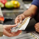 A person handing over a coupon to a supermarket employee