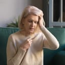 An older woman holding her head in pain