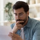 close-up of a worried man reading something from the paper he's holding in his hand
