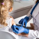 Young girl getting a shot from a doctor