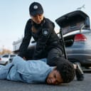Female officer forcefully arresting a man on the ground