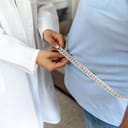 Doctor measuring the circumference of a person's waist