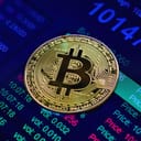 A golden coin with a Bitcoin symbol on an exchange rate screen