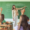 students raising their hands to answer to a teacher's question during a math class