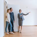 Realtor showing a house to a young couple.