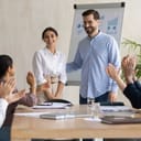 Woman being praised by her coworkers at a meeting