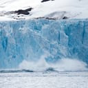 An iceberg breaking off from a glacier