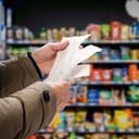 a man checking receipts in supermarket after grocery shopping