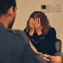 A detective listen to a woman during an interrogation at the station.