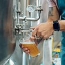 Man pouring beer into a cup from a large container