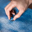 The missing piece of the sky puzzle, the concept of completing a big job, the final of the project, the successful solution of business problems. The hand puts the last piece of the jigsaw