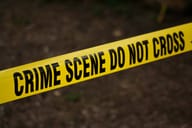 Police ribbon reading "CRIME SCENE DO NOT CROSS"