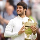 Carlos Alcaraz holding a trophy.