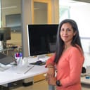Female executive standing in front of a desk.