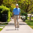 Elderly man walking along a path.