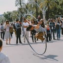 Street performer doing acrobatics using a large metal ring.

