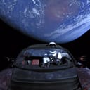 Elon Musk's Tesla Roadster mounted to a Falcon Heavy rocket in space above Earth.