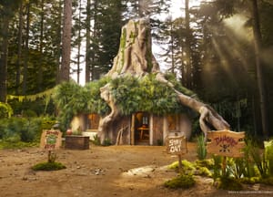 A tree trunk looking house made to look like Shrek's home