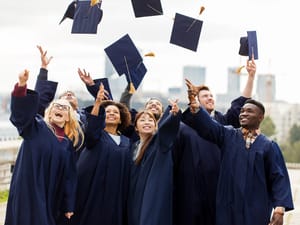 Graduate students throwing graduation caps in the air